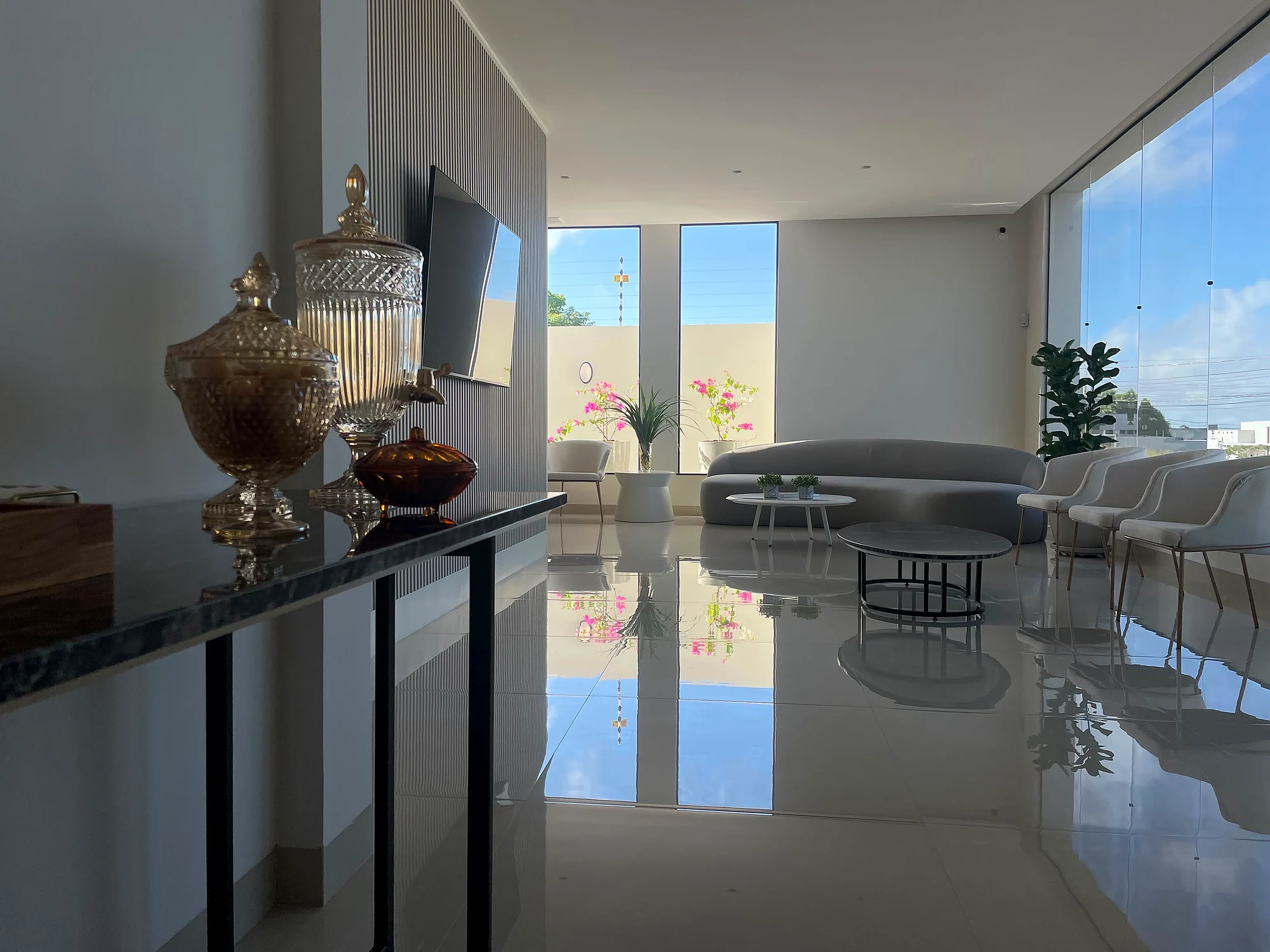 Estar da Clínica ND, com poltronas, sofá curvo e janelas panorâmicas