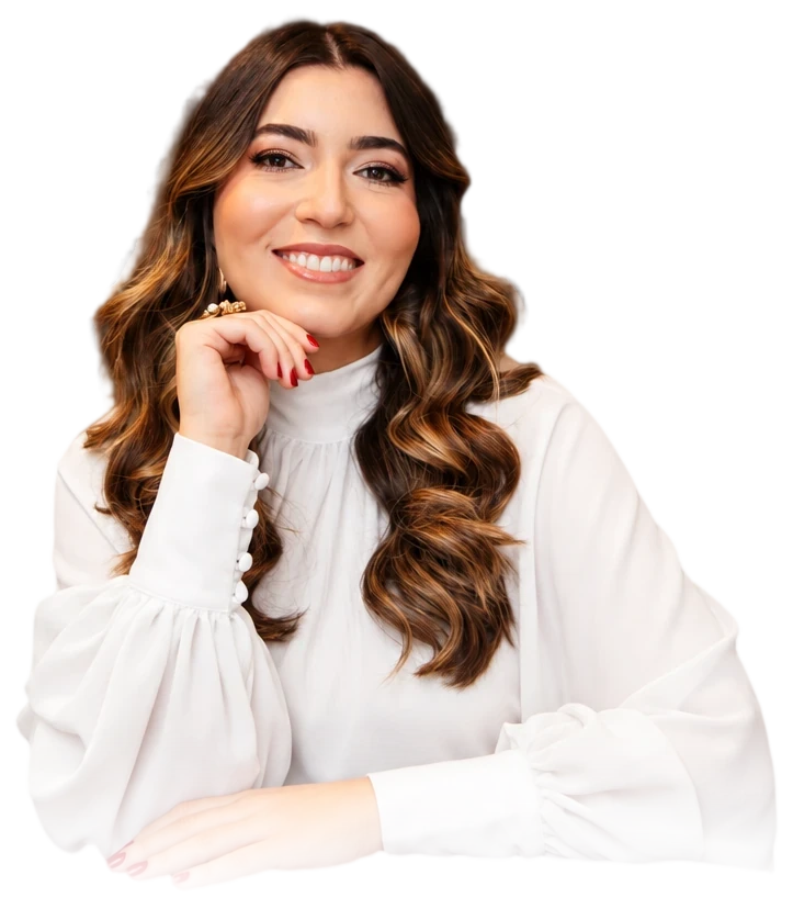 Dra. Nabila Demachki sorrindo, com a mão no rosto e os braços apoiados